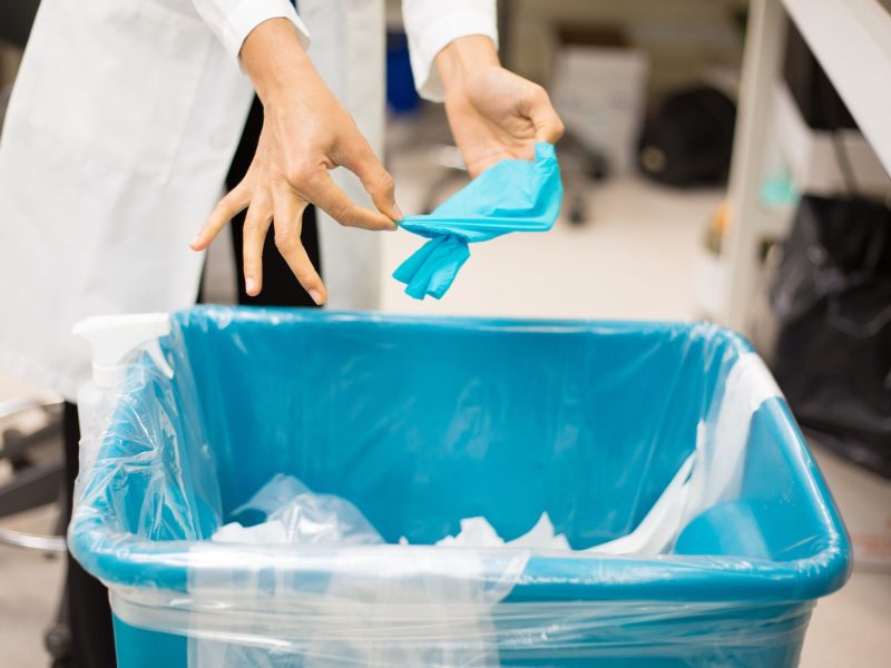 Woman-removing-glove-in-trash-1